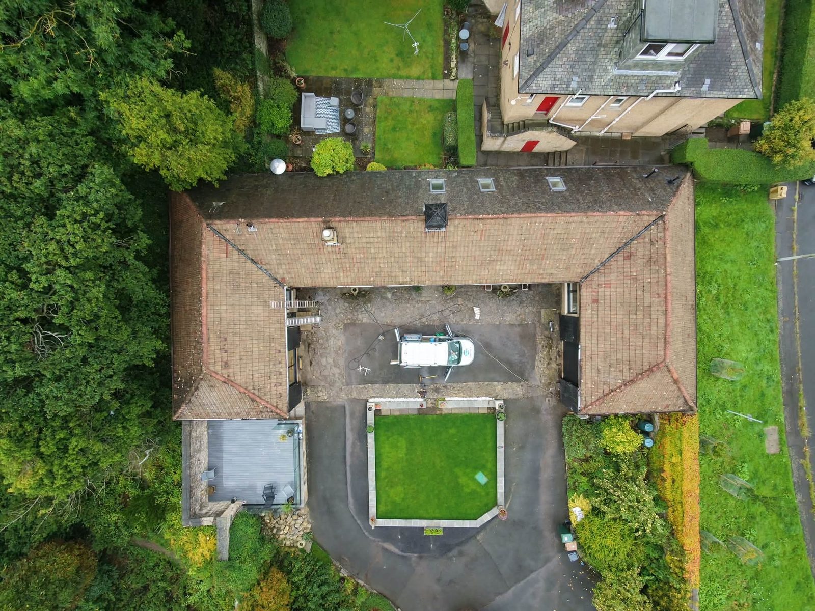 Aerial view of a tiled roof with the Christie's Exterior Cleaning van in the courtyard below