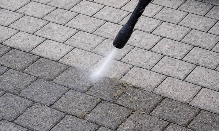 A pressure washer lance cleaning block paving