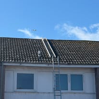 Scheduled gutter maintenance access on a tiled roof